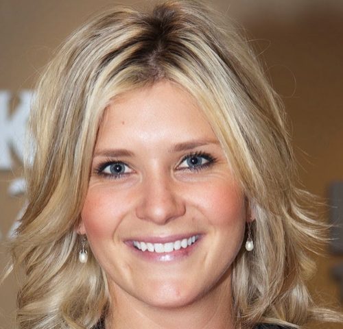 A woman with blonde hair smiles for the camera.